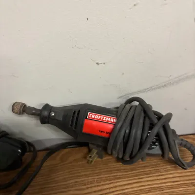 Craftsman two-speed corded rotary tool with attached sanding drum bit and power cord wrapped around the body.