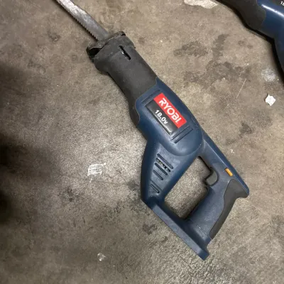 Ryobi 18.0V cordless reciprocating saw with attached blade, showing light scuffs from use.