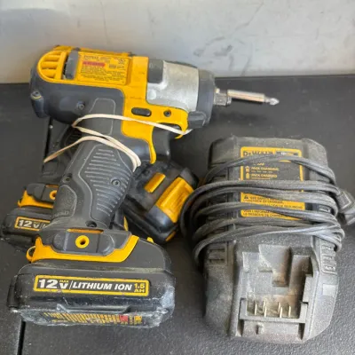 DeWalt 12V Max cordless impact driver set, including a 1.5 Ah lithium-ion battery and charger. The tools show heavy signs of use and...