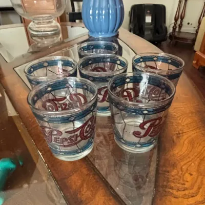 Set of vintage Pepsi-Cola stained glass style drinking glasses, featuring blue borders and red script logos.