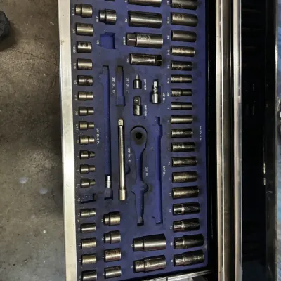 Organized toolbox drawer filled with SK brand socket sets and extension bars in a blue foam insert.