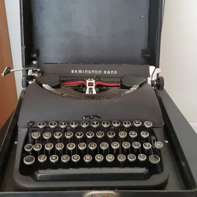 Vintage black Remington Rand Deluxe Model 5 portable manual typewriter housed in its original hard carrying case.