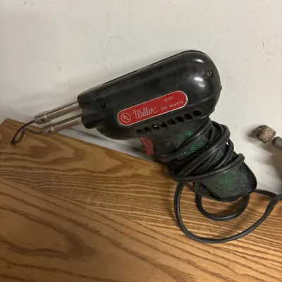 Vintage Weller model 8100 100-watt soldering gun with a black housing and coiled cord.