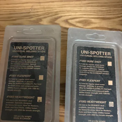 Two plastic packages of Uni-Spotter universal welding studs, made in Canada.