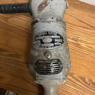 Vintage Sioux heavy-duty portable electric polisher featuring a durable metal body with side handle, showing significant finish wear and...