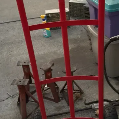 Red heavy-duty steel hand truck with rubber tires, shown in gently used condition.