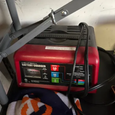 Cen-Tech red portable 12-volt automotive battery charger featuring a 50-amp emergency engine start option.