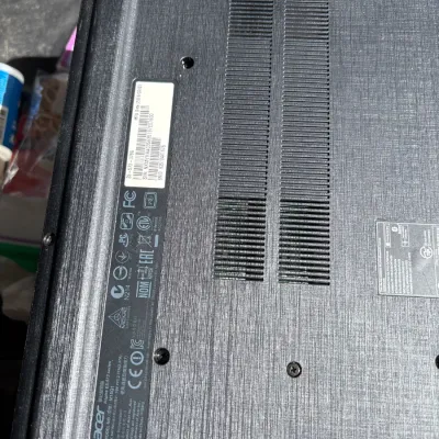 Underside of an Acer Aspire E5-573 series laptop showing model details and serial number sticker.