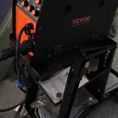 Vevor MIG-270 inverter welding machine mounted on a black metal rolling cart, in like-new condition with original manual and accessories...