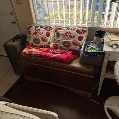 Vintage wooden storage bench featuring two San Francisco 49ers throw pillows and a matching fleece blanket.