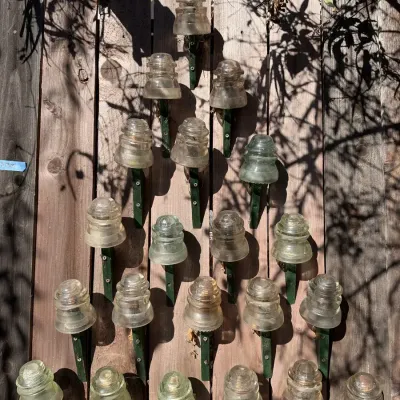 Classic Glass Pole Insulator Collection Dominion Marked on Green Wood Stakes