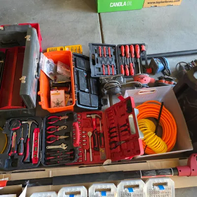 Sale Photo Thumbnail #140: Large assortment of hand tools, power sanders, and hardware storage cases, including socket sets, screwdrivers, pliers, and an extension cord.