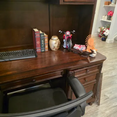 Sale Photo Thumbnail #38: Traditional dark wood executive desk with hutch and office chair, featuring decorative items including faux book sets, a toy motorcycle, and small tabletop accents.