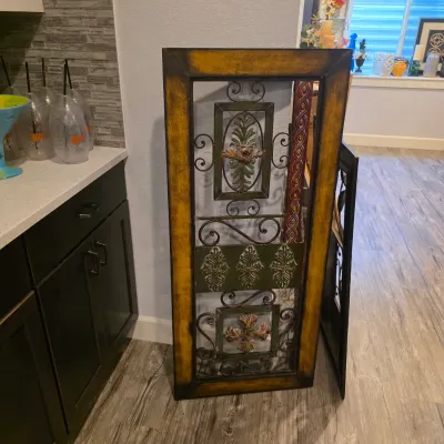 Sale Photo Thumbnail #30: Tall wrought iron and wood decorative wall panel featuring a distressed gold-finish frame, scrollwork, and painted floral motifs.