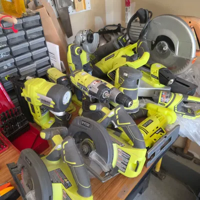 Sale Photo Thumbnail #123: Collection of modern Ryobi 18V ONE+ cordless power tools, including circular saws, drills, sanders, an AirStrike nailer, and flashlight.