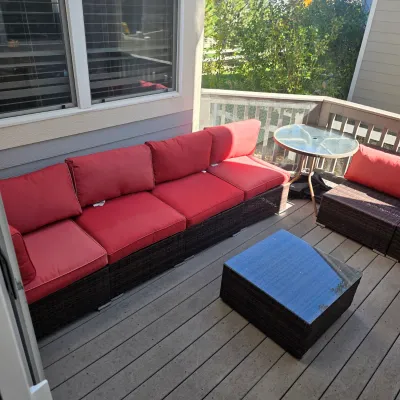 Sale Photo Thumbnail #64: Modern resin wicker outdoor patio sectional set featuring dark brown woven bases, bright red cushions, and a matching square coffee table with a glass top.