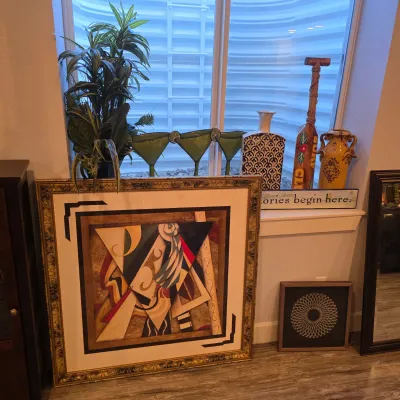 Sale Photo Thumbnail #26: Large framed abstract artwork in a gold ornate frame, displayed alongside various home decor items including ceramic vases, a decorative wooden paddle, and potted plants.