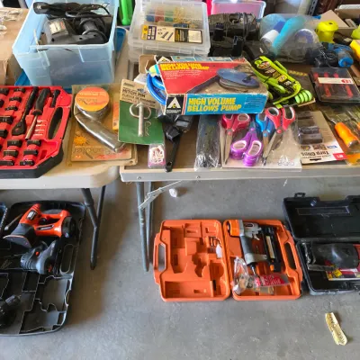 Sale Photo Thumbnail #126: Assortment of power tools, hand tools, and hardware, including a socket wrench set, nail guns in cases, vintage High Volume Bellows Pump in original box, and plastic storage bins.