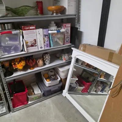 Sale Photo Thumbnail #52: Storage shelves filled with baking tools, glassware, and decorative home goods next to a large white framed wall mirror.