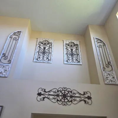 Sale Photo Thumbnail #108: Collection of Tuscan-style decorative wall art pieces, including distressed wooden frames with wrought iron scrollwork grilles.