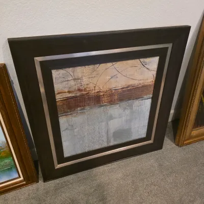 Sale Photo Thumbnail #17: Large square contemporary abstract canvas print featuring neutral beige, rust, and grey tones, housed in a thick dark frame with metallic accents.