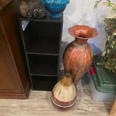 Sale Photo Thumbnail #14: Collection of decorative home accents, including a large copper-toned floor vase, a striped ceramic vase, a blue Moon and Star pattern glass bowl, and a black three-tier cubby shelf.