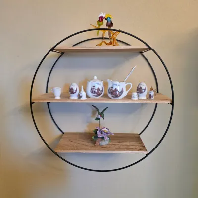 Sale Photo Thumbnail #72: Modern circular metal and wood wall shelf holding miniature porcelain knick-knacks and decorative figurines.
