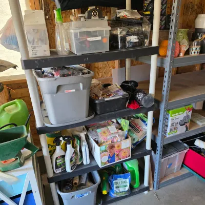 Sale Photo Thumbnail #135: Black four-tier plastic shelving unit loaded with various lawn, garden, and household storage supplies.