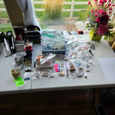Sale Photo Thumbnail #161: Large assortment of costume jewelry, watches, and accessories displayed on a folding table, individually packaged in plastic bags.