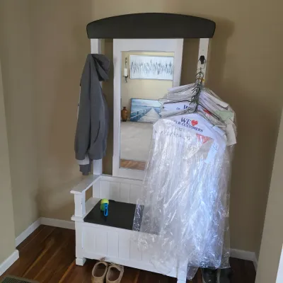 Sale Photo Thumbnail #84: White wooden hall tree featuring a dark grey top panel, central tall mirror, and lower bench seat with storage.