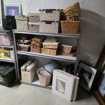 Sale Photo Thumbnail #62: Large collection of storage baskets in various sizes, styles, and woven materials displayed on metal shelving, accompanied by lampshades and picture frames.