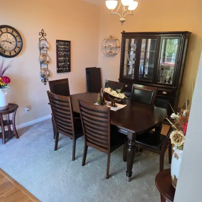 Sale Photo Thumbnail #66: Traditional dark wood dining room suite including an oval table with six slat-back chairs and a matching glass-front hutch cabinet.