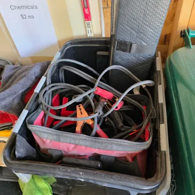 Sale Photo Thumbnail #147: Black plastic storage crate packed with automotive jumper cables stored inside a red canvas tool bag.
