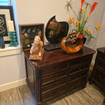 Sale Photo Thumbnail #35: Traditional dark mahogany chest of drawers displayed with decor, including a vintage golf memorabilia shadowbox, a sculpted horse statue, and modern art pieces.