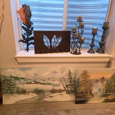 Sale Photo Thumbnail #22: Collection of home decor including two large canvas landscape paintings, a metal leaf design candle holder, a tree branch votive holder, and decorative pillar candle stands.