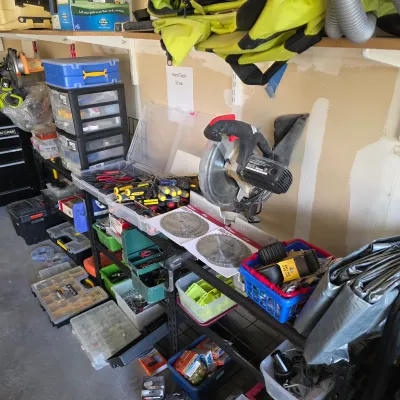 Sale Photo Thumbnail #148: Workshop shelving loaded with power tools, hand tools in plastic organizers, circular saw blades, and various hardware.