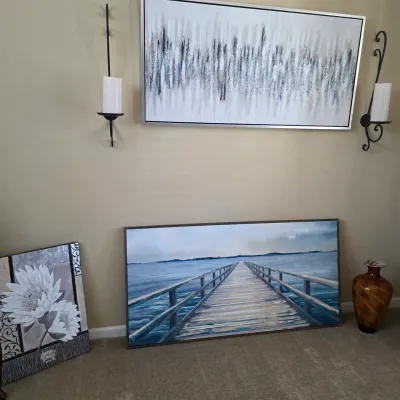 Sale Photo Thumbnail #80: Contemporary home decor collection including framed abstract and pier wall art, black wrought iron candle sconces, a botanical canvas, and an amber swirled art glass vase.