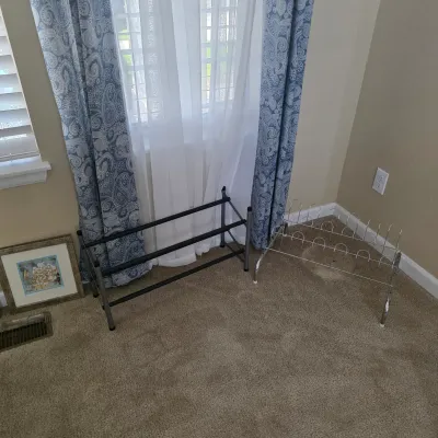 Sale Photo Thumbnail #83: Two freestanding shoe racks, including a dark metal multi-bar rack and a chrome wire boot rack, shown in clean condition.