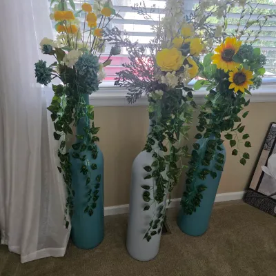 Sale Photo Thumbnail #78: Set of three oversized bottle-shaped floor vases with faux floral arrangements and trailing ivy greenery.