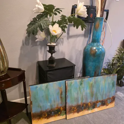 Sale Photo Thumbnail #20: A pair of contemporary abstract paintings on canvas with matching turquoise and earth-tone colors, displayed near a tall turquoise ceramic floor vase and artificial floral arrangement.