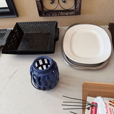 Sale Photo Thumbnail #199: Collection of tabletop kitchenware and decor including a blue ceramic lantern, perforated metal grilling topper, serving platter, and skewers.