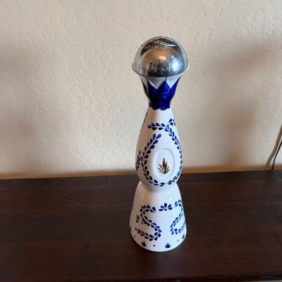 Sale Photo Thumbnail #37: Hand-painted Clase Azul Reposado tequila ceramic bottle featuring traditional cobalt blue leaf patterns and a silver-toned bell stopper.