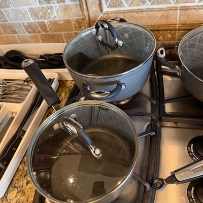 Sale Photo Thumbnail #184: Set of gray non-stick cookware including a saucepan and stockpot with tempered glass lids.