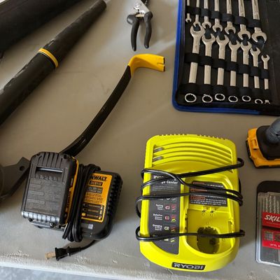 Sale Photo Thumbnail #78: Assorted modern hand and power tools, including a Ryobi battery charger, DeWalt battery and charger, pry bar, pruning shears, and a metric wrench set in a roll-up pouch.