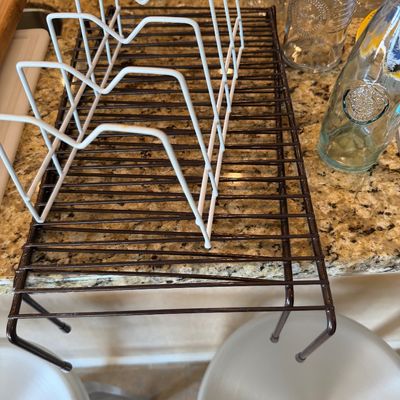 Sale Photo Thumbnail #201: Brown wire over-sink or counter drying rack alongside a white coated metal pot lid organizer.