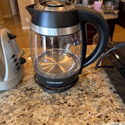 Sale Photo Thumbnail #188: Chefman electric glass kettle with black and stainless steel accents, sitting on a granite countertop.