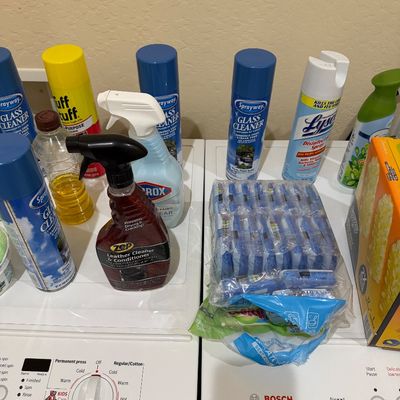Sale Photo Thumbnail #104: Assorted household cleaning supplies, including Sprayway glass cleaners, Lysol disinfectant spray, and Zep leather conditioner, set on a Bosch washer and dryer.