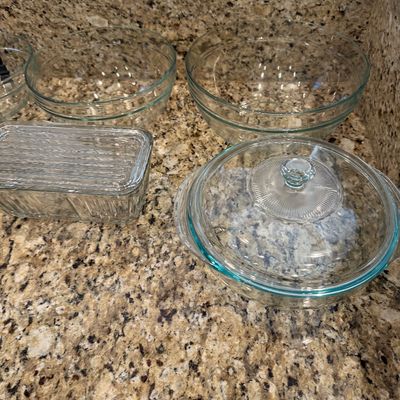 Sale Photo Thumbnail #190: Collection of clear Pyrex glass cookware and mixing bowls, including a covered casserole dish, rectangular lidded container, and nesting mixing bowls.