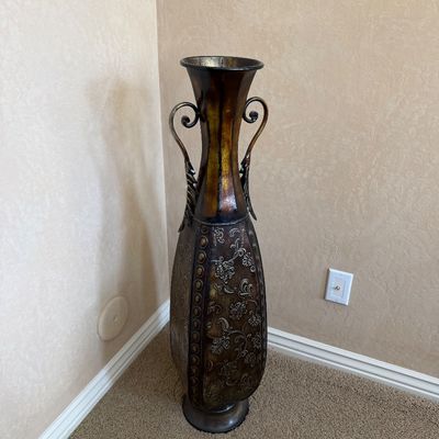 Sale Photo Thumbnail #221: Tall decorative metal floor vase featuring scrolled side handles and embossed floral filigree details.
