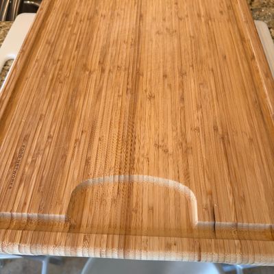 Sale Photo Thumbnail #204: Large Food Network brand bamboo cutting board featuring a perimeter juice groove and carved handle section.